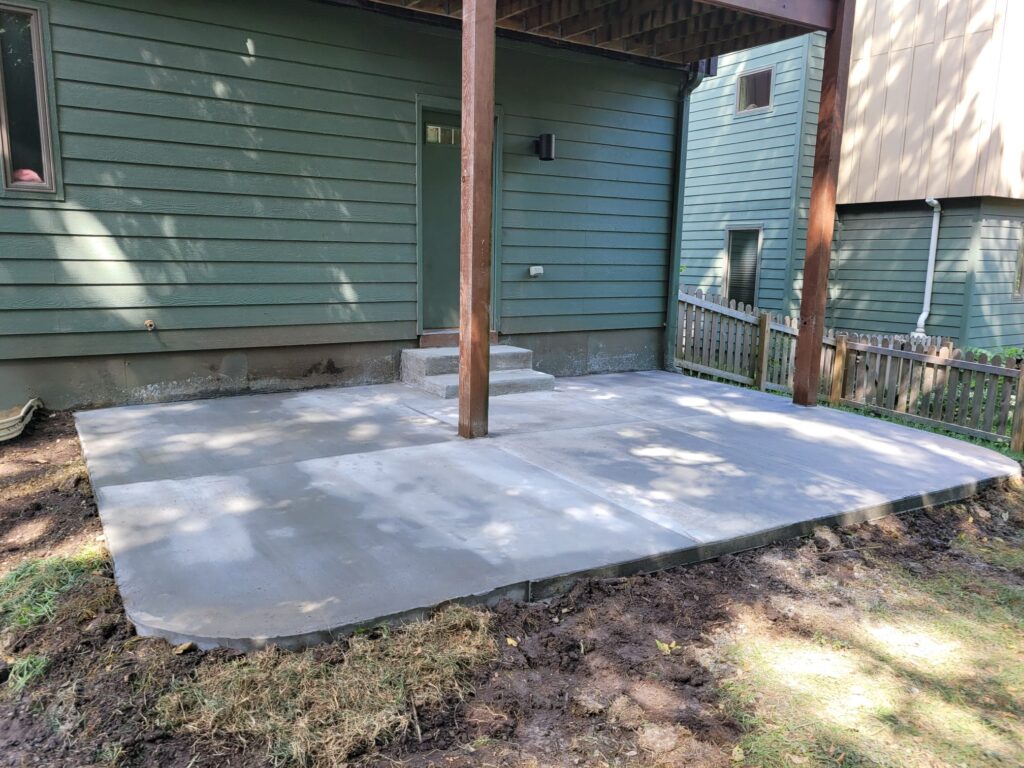 Add a touch of sophistication to your backyard with a rounded corner patio and concrete stairs from Eagle Stone Concrete. Featuring a bare color and a broom finish, perfect for summer barbecues and gatherings, this patio is sure to be a favorite spot for relaxation and entertainment. Select from a range of colors and patterns. Contact us today for a free quote!