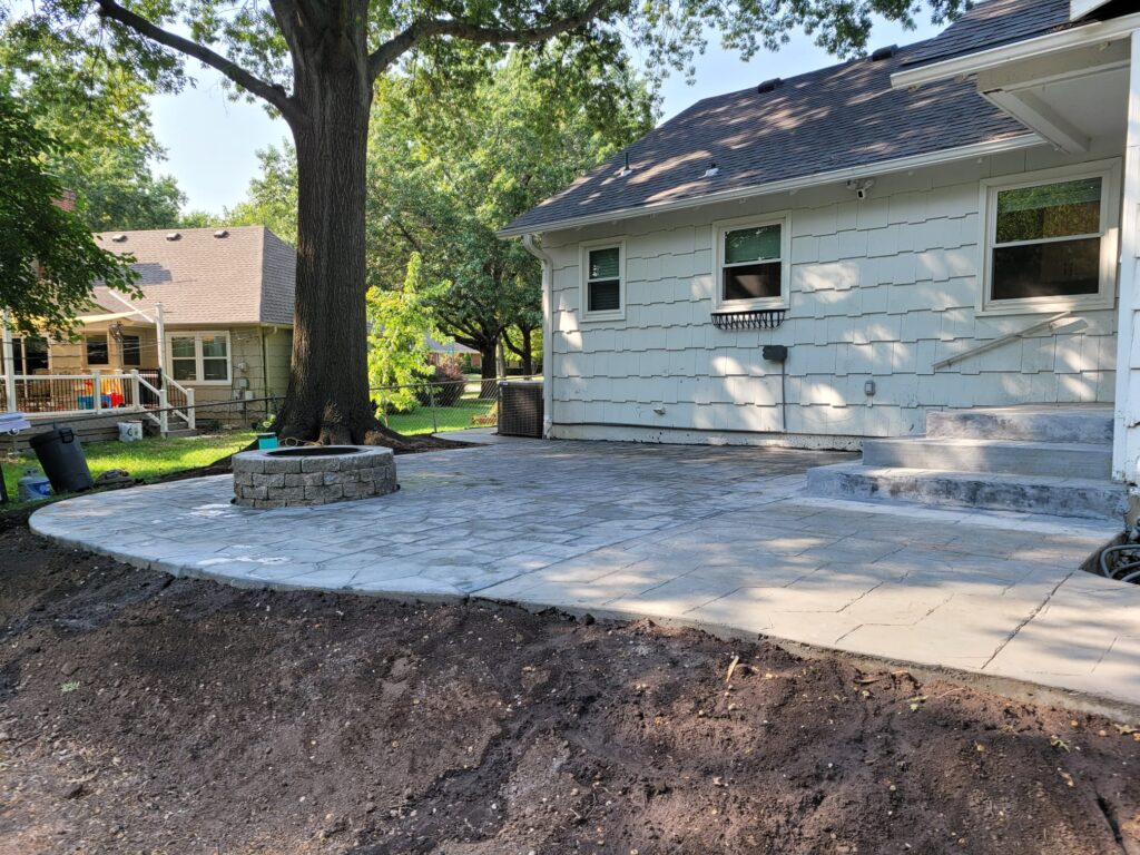 Discover how Eagle Stone Concrete designed a seamless connection between a driveway and patio with a winding sidewalk that navigates around a mature tree. Additionally, the patio features a cozy firepit, and the project includes a dedicated slab for a toolshed. Enhance your outdoor space with both beauty and functionality. Contact us today for a free estimate!